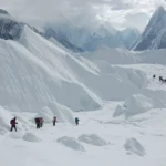 The sharp rock fin of Mitre Peak rising above the Baltoro Glacier with the Gasherbrum group in mist behind