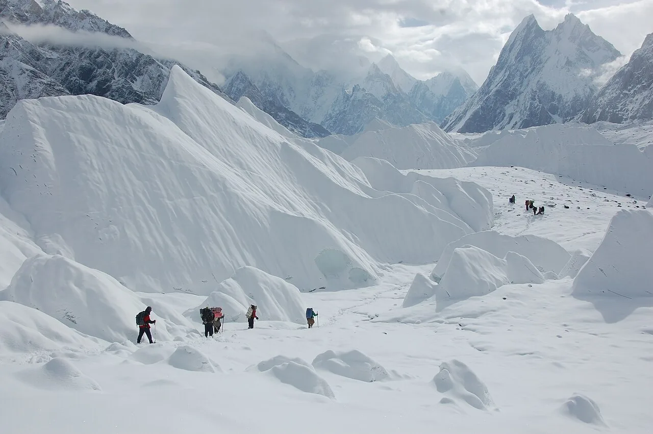The sharp rock fin of Mitre Peak rising above the Baltoro Glacier with the Gasherbrum group in mist behind