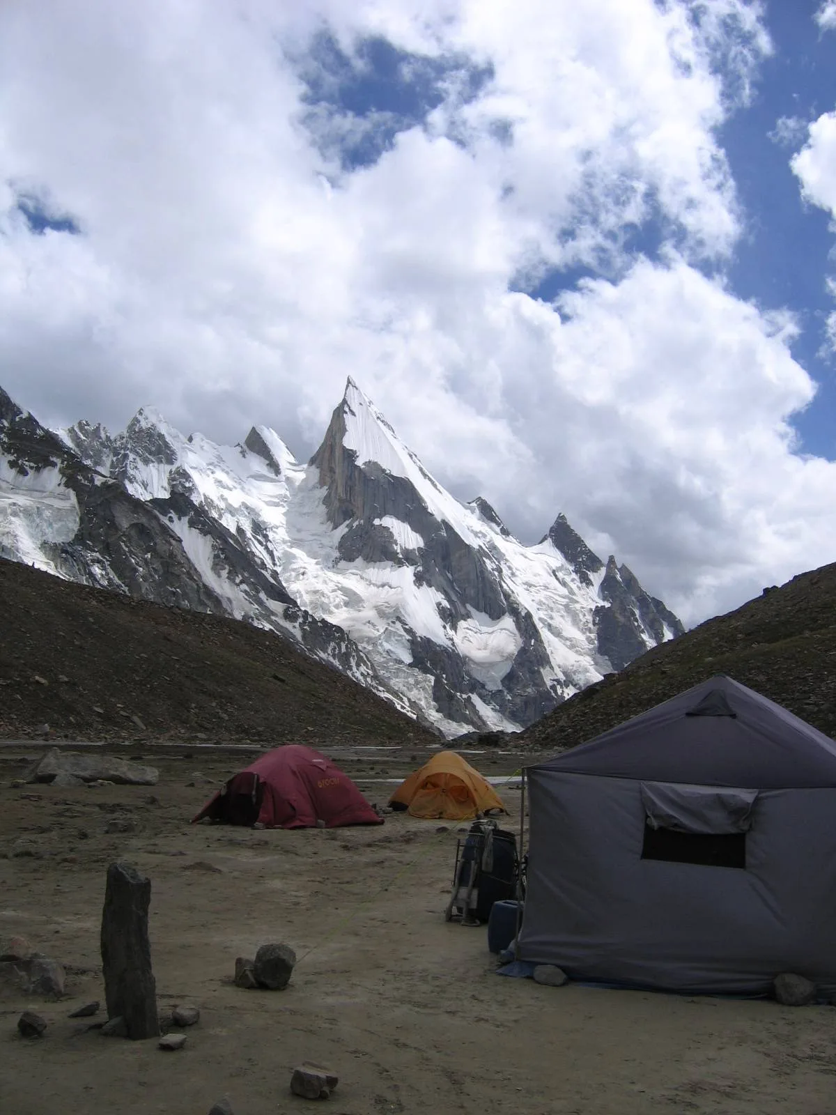 A trekking camp on the Gondogoro Glacier moraine with the spear of Laila Peak towering behind