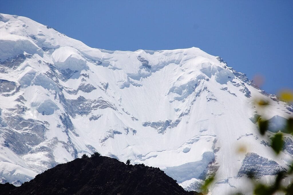 Rakaposhi rising above the green meadow of Tagaphari, the Rakaposhi Base Camp