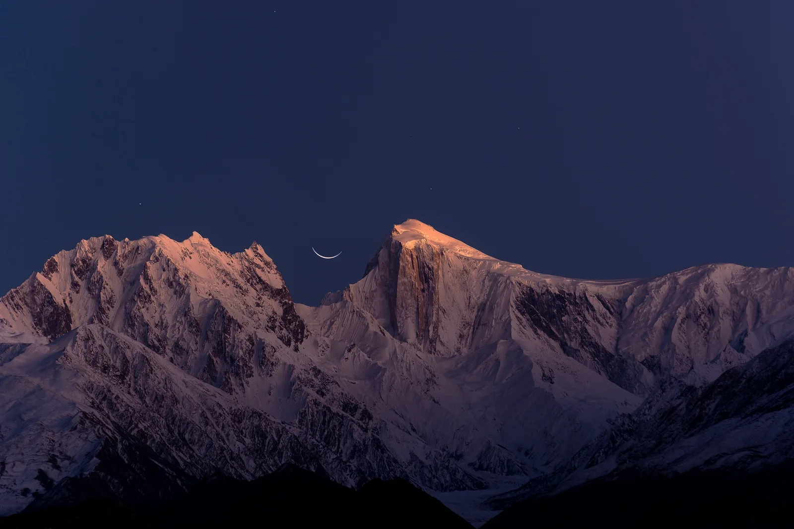 Dusk light on Spantik (Golden Peak) with a crescent moon above the Karakoram skyline