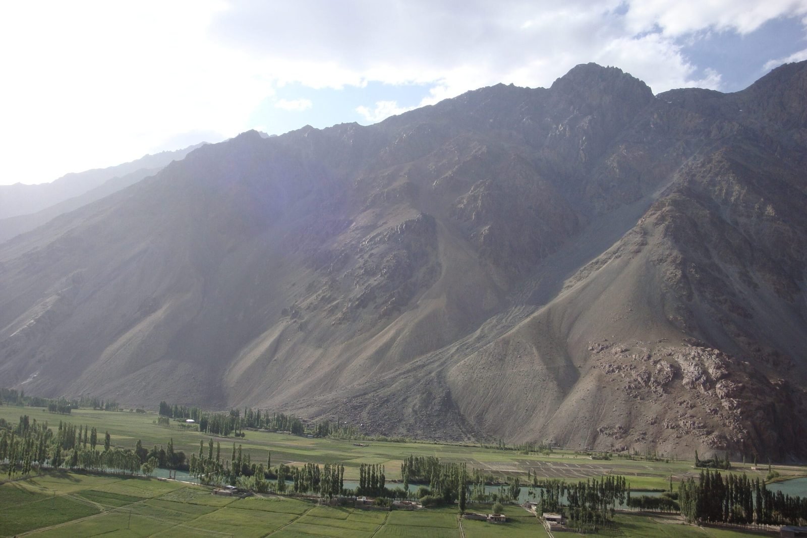 Le lac de la vallée de Phander entouré de champs verts et de montagnes, Ghizer, Gilgit-Baltistan