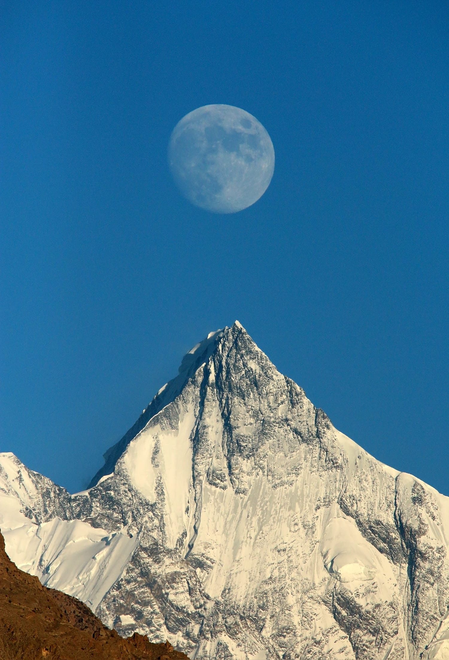 Moon rising above the snow summit of Lupghar Sar seen from Aliabad, Hunza