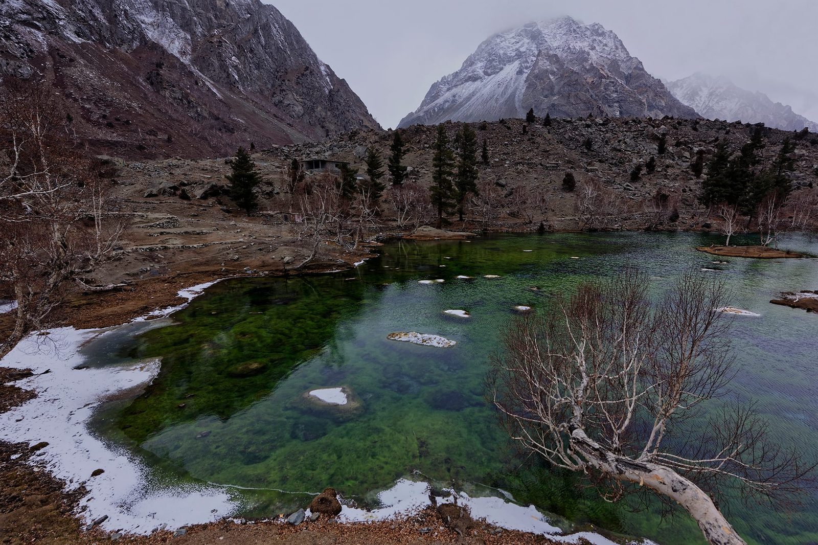 Un lago turchese di Naltar circondato da montagne sopra il villaggio