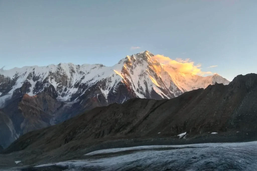 Alpenglow lighting a Karakoram peak above a glacier at dusk