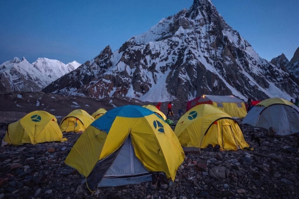 Expedition tents at Concordia at dusk beneath Mitre Peak on the Baltoro Glacier