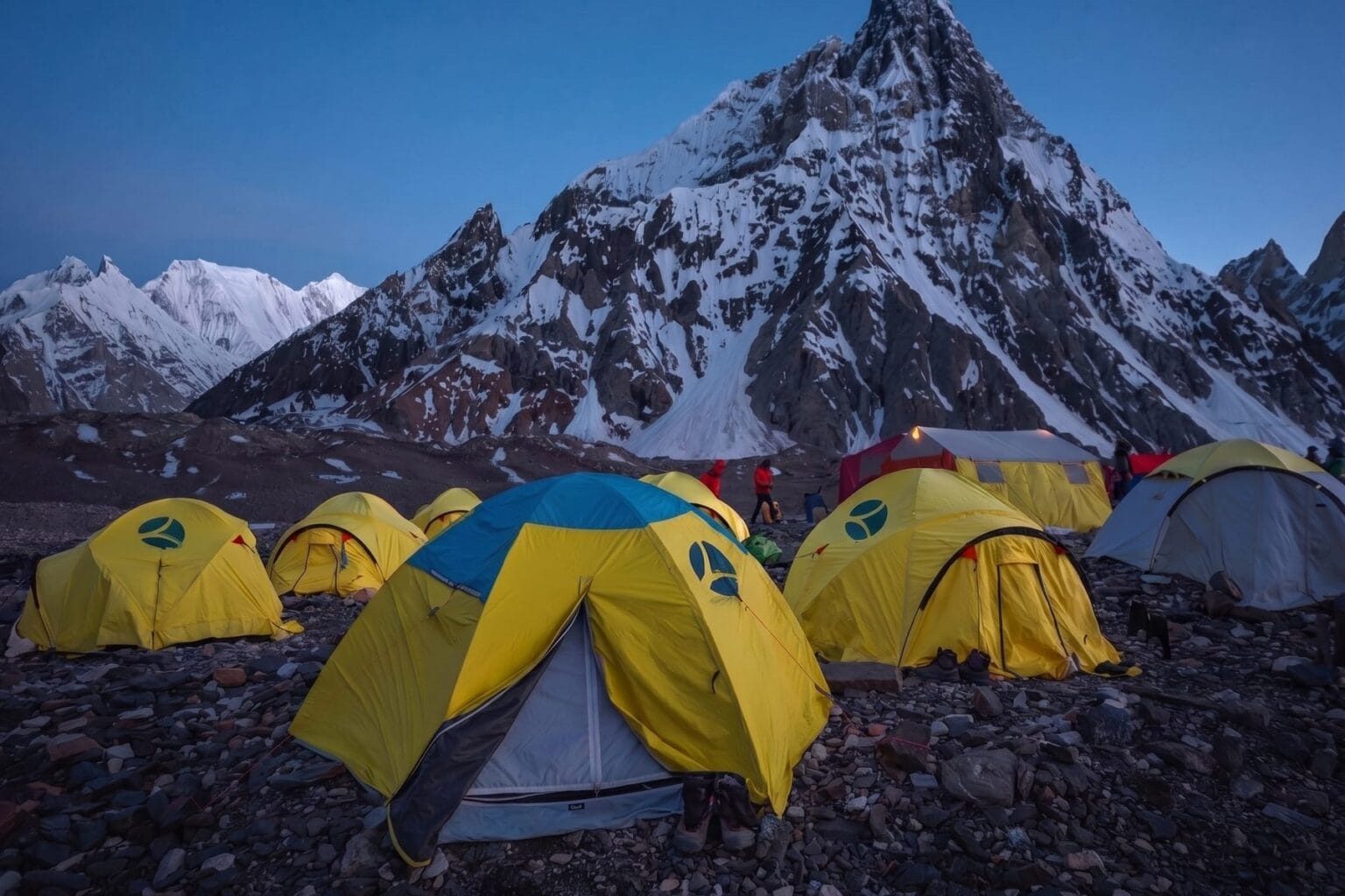 Expedition tents at Concordia at dusk beneath Mitre Peak on the Baltoro Glacier