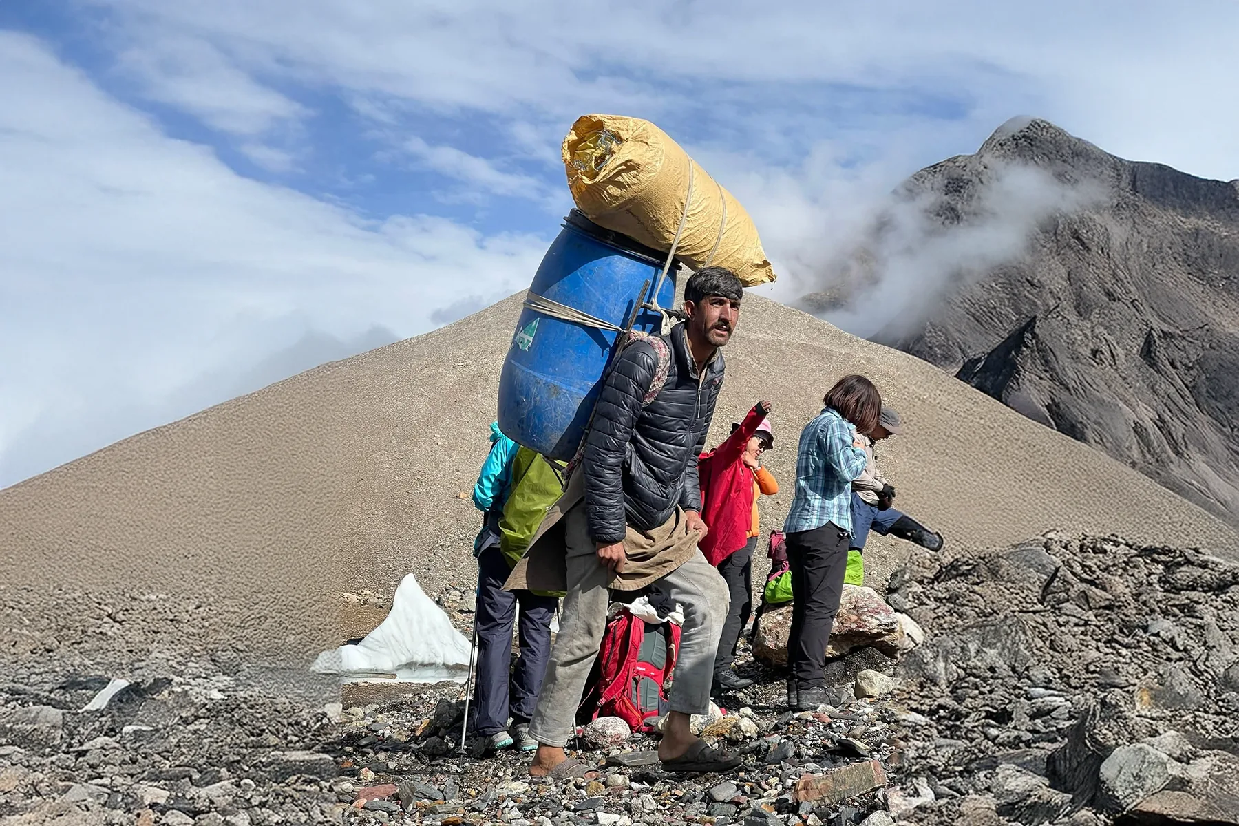 Porteur transportant une charge d'expédition sur un sentier du Karakoram