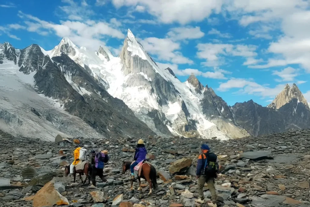 Trekking group with pack horses crossing a moraine field
