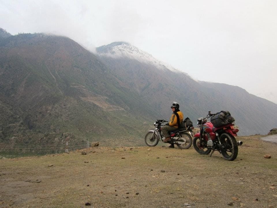 Deux motos de tourisme arrêtées au-dessus de la vallée de l'Indus sur la Karakoram Highway, dans le Kohistan